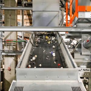 Sorteringsband med plastförpackningar inuti en sorteringsanläggning.