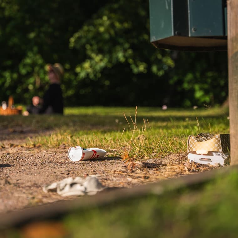 Förpackningsavfall som ligger marken i en park.