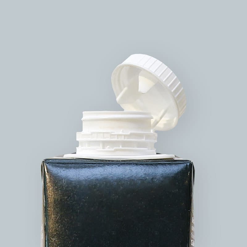 En närbild på en dryckeskartong med fastsatt plastlock.