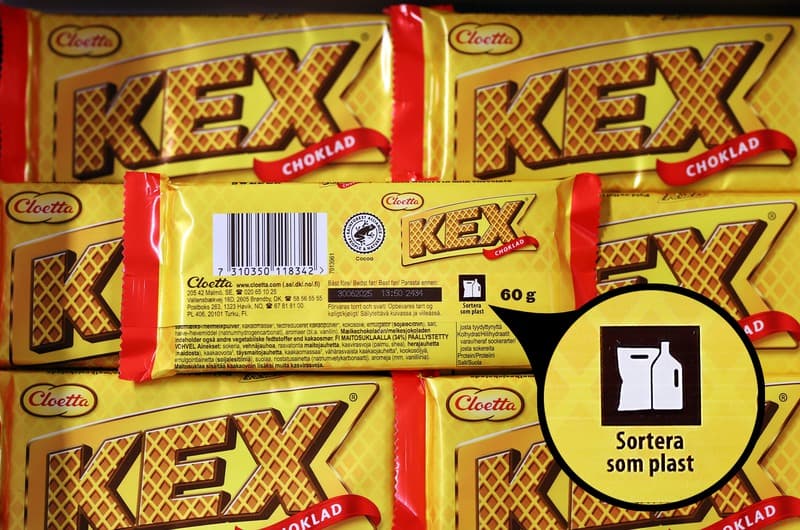 Närbild på kexchoklad med märkning som visar att förpackningen ska källsorteras som plast.