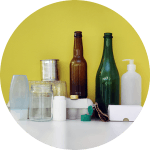 Förpackningar i olika materialslag mot en gul bakgrund.