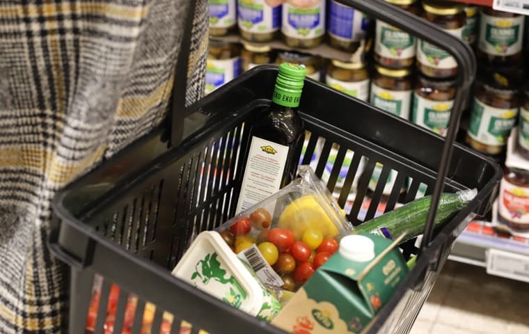 Bilden visar en korg med förpackade varor i en matbutik.